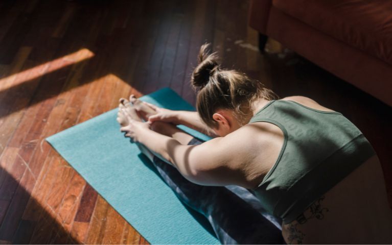 ragazza che pratica yoga assumendo una postura che facilita il benessere dell'intestino