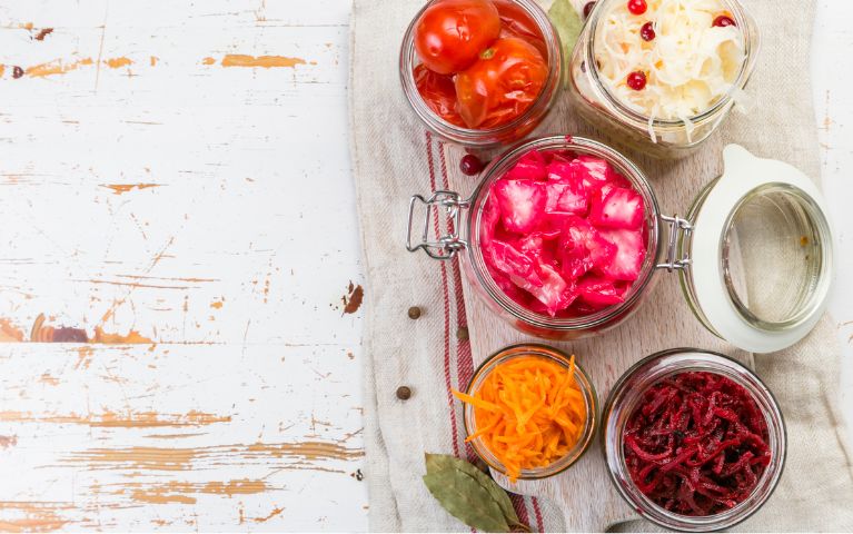 alcuni alimenti ricchi di probiotici all'interno di barattoli di vetro su un tavolo