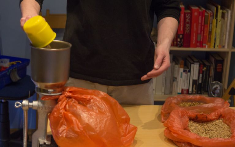 homebrewer che macina i malti per la preparazione della birra con metodo allgrain