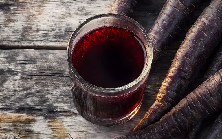 Şalgam, bevanda di carote nere fermentate, con rifless rossi intensi in un bicchiere